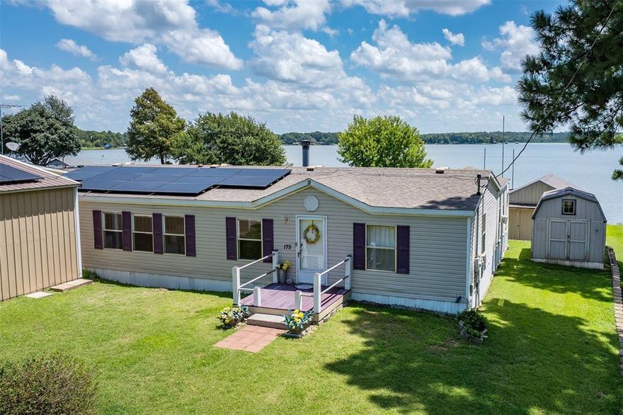 Great open water views! Short term rental friendly.
Come kick back and enjoy the good life in this roomy 4-bedroom, 2-bath Palm Harbor home with plenty of extras. Outside, the beautiful open water views facing east are amazing!  Inside, you’ll find a comfortable living room with a cozy wood-burning fireplace, new floors, and a large laundry room with loads of storage. You’ll love the large kitchen with a big island and lots of cabinets. The living room opens to an enclosed porch featuring lots of windows —perfect for morning coffee or evening get-togethers.
The property is designed for easy living and big gatherings, with a wraparound porch, screened gazebo, and an extra shed with a porch that could serve as a bunkhouse, bar or hobby space. The huge garage-shop offers tons of storage for tools, toys, and projects.
Located on open water in a large cove, you’ll enjoy fantastic water views and quick lake access, plus a neighborhood boat ramp just down the road. Solar panels (paid off at closing) keep your electric bills low, and you’ll have two 50-gallon water heaters to handle all the hot water you need. POA dues are already covered through July 2026, so you can settle in without extra worry.
This home is made for relaxed lake days, fireside nights, and plenty of room for family and friends. Schedule your private showing today!