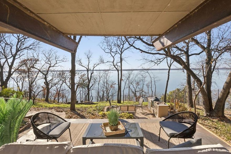 Architecturally distinctive Lake Lewisville waterfront residence situated on a 1.44-acre elevated peninsula in the Emerald Sound community, offering exceptional privacy, panoramic lake views, and direct access to the water. Designed by GGOArchitect Gary Olp, the home reflects a thoughtful integration of passive solar design, sustainable materials, and site-responsive architecture that preserves mature Texas native trees.

Expansive south- and east-facing windows with architectural overhangs provide abundant natural light while supporting year-round energy efficiency. Strategically placed north and west openings contribute to balanced interior climate control. Five Andersen double-pane glass door systems connect interior living spaces to gardens, patios, and lake views.

The cantilevered primary suite extends toward the shoreline, creating a private retreat with sunset views over the lake. Outdoor living areas include a Rumford fireplace, a sunken stone patio kitchen, and a landscaped spa setting surrounded by drought-tolerant plantings and herb gardens. A constructed pathway leads to the water’s edge with kayak storage and convenient lake access.

The exterior features cementitious stucco, ICF construction, and a standing-seam metal roof, offering durability, sound insulation, and thermal performance. The lower level provides additional storage and a temperature-controlled wine cellar. All bathrooms throughout the home have been updated, and the kitchen is enhanced by brand-new appliances, including dual ovens. A second-floor Eagle’s Nest loft features a widow’s watch window.

The property includes a four-car garage with a private guest suite offering an ensuite bath, walk-in closet, and light kitchenette designed for beverage and snack preparation. A rare opportunity to own a design-driven, energy-efficient waterfront home in one of Lake Lewisville’s most private and elevated settings.