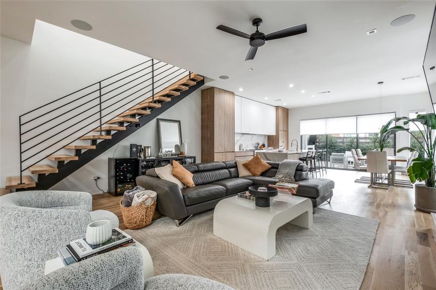 Nestled on a quiet, tree-lined block in the heart of Dallas, this architecturally curated home offers a combination of luxury and livability, within walking distance to both Henderson Avenue and Lower Greenville. Completed in 2022, this light-filled modern was designed with intentionality. White oak hardwood floors anchor an open floor plan that flows beneath 10ft ceilings, while an abundance of natural light pours through thoughtfully positioned windows. Level 4 finish walls, custom roller shades, and a dramatic floating metal staircase speak to the caliber of craftsmanship found throughout. The main living area is centered around a gas fireplace with a sleek quartz surround, opening gracefully into a dining space appointed with a custom light fixture — a natural gathering place designed for both intimate evenings and elegant entertaining. The chef's kitchen is nothing short of exceptional, featuring an oversized quartz waterfall island with counter seating, fully custom cabinetry, and a suite of premier appliances including a built-in Fisher & Paykel refrigerator-freezer, Gaggenau dishwasher as well as a microwave and a six-burner gas range with oven. Glass panel stacking doors dissolve the boundary between indoors and out, leading to a landscaped private backyard complete with a fireplace, patio, and an integrated six-speaker audio system — four inside, two al fresco — setting the stage for year-round outdoor living. A first-floor powder room dressed in custom Gucci wallpaper adds a moment of playful sophistication. A gated entry ensures both security and privacy throughout. Upstairs, a skylit corridor guides you to three well-appointed bedrooms, including an oversized primary suite with a spa-caliber bath featuring a soaking tub, glass-enclosed shower, and a generous walk-in closet. A dedicated second-floor utility room offers full-size stackable laundry and additional storage. An oversized two-car garage completes this impeccably considered home.