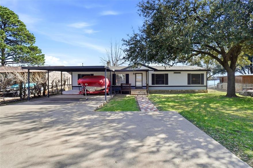 Make memories that last a lifetime! Experience the ultimate lakefront lifestyle in this 3-bedroom, 2 bathroom retreat, perfectly positioned directly on the main body of Lake Granbury. If your looking for big water views and deep water access, this is the one! The interior is designed for both relaxation and entertaining, featuring two living areas that provide ample space for guests to spread out. A cozy wood burning fireplace offers the perfect focal point for chili evenings after a day on the water. The kitchen, complete with an inviting eat in area, flows seamlessly into the main living spaces, making morning coffee with a view a true luxury. The outdoor amenities truly set this property apart. Step out onto the spacious covered deck, an ideal vantage point for shaded afternoons or late night stargazing over the open water. This home is fully fenced offering a secure environment for pets or play, and includes a convenient storage shed for all your lake gear and fishing tackle. Parking is a breeze with the double carport, providing protection for our vehicles and toys. Water enthusiasts will fall in love with the private dock, granting you immediate access to boating, wakeboarding, fishing, floating, or sunset cruises right from your own backyard. Nestled in a wonderful established neighborhood you'll enjoy the peace of a private oasis alongside fantastic community amenities.   Whether looking for a full time residence or a weekend getaway, this home offers the perfect setting to make great memories on the Lake. Don't miss your chance to own a piece of Lake Granbury's most sought after shoreline!
Home is Certified Manufactured home. Please see Offer Guidelines in Transaction Desk.