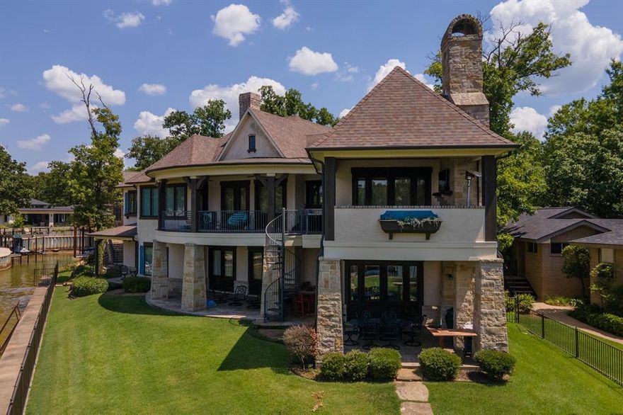 Waterfront living in this sought after golf course, gated country club community just an hour from Dallas. This spectacular home has a French country design with heavy beam accents, vaulted ceilings and balconies overlooking the lake. En suite baths for guests including a built in bunk wall in a family suite. Separate guest suite with private entry and lake access. Covered patios with gas outdoor fireplace, outdoor grilling area that connects to fun entertaining space with second kitchenette, warming drawers, bar space perfect for steaks and cocktails at the water's edge! Double boat slip dock. You will love the protection of this cove location along with the open water views from the patios! Enjoy safe floating- swim fun and smooth boat navigation for optimal lake experience! The club house is just a short golf cart ride away for dining, pool, tennis or 18 holes of golf! Social membership included in POA dues to include dining- swim and tennis.