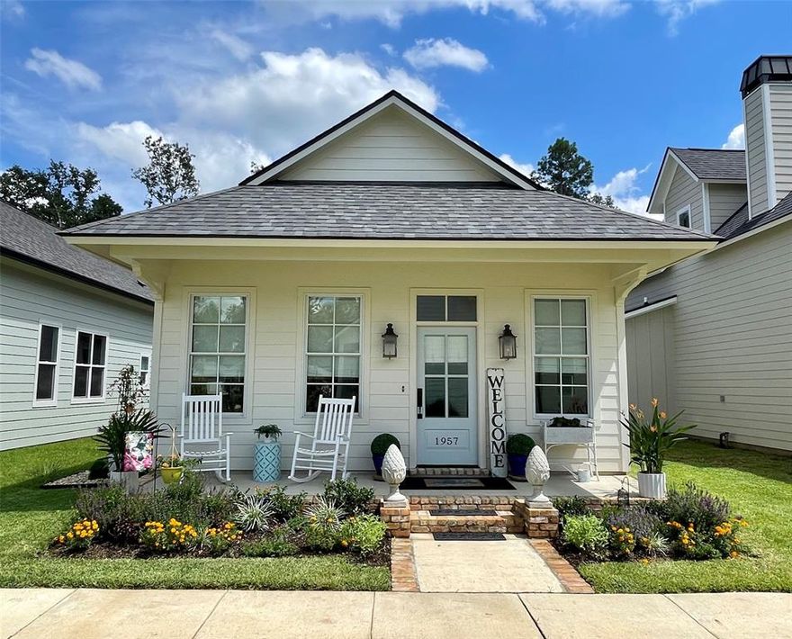 Cherished Garden Cottage welcomes you home—an inviting retreat that lives beautifully beyond its square footage. From the New Orleans–style front porch to its park-side setting with sunset views, every detail is designed for easy, gracious living. Out back, a thoughtfully curated garden and outdoor living space create a peaceful escape to unwind or entertain.

Inside, the layout is just right for gathering with friends or enjoying a quiet evening with a good book. The open living, dining, and kitchen areas flow effortlessly together. The kitchen is crisp and timeless, featuring white finishes, stainless steel appliances—including the refrigerator—and an island perfect for morning coffee or evening conversation. A spacious walk-in laundry and pantry keeps everything neatly tucked away, with washer and dryer included for added convenience.

Down the hall, a full bath with tub-shower combination sits conveniently across from the secondary bedroom.

Privately located at the rear of the home, the primary suite easily accommodates a king-sized bed and offers a generous walk-in closet. The ensuite bath features abundant counter space and a beautifully tiled walk-in shower.

Step outside to an enchanting garden retreat. A covered patio with gas grill connection and twinkling lights sets the tone for relaxed evenings. Lush plantings—hydrangeas, roses, blueberry bushes, and more add charm and color, while the fully fenced yard provides privacy and space for both pets and bare feet in the grass. The garage-carport combination enhances the open feel, complemented by a large storage room to keep everything in its place. An EV plug is already in place, and the alley-loaded drive offers ample parking for guests.

It’s more than a home—it’s a place to settle in, slow down, and stay awhile.

Enjoy the Provenance lifestyle and all it has to offer in this charming cottage.