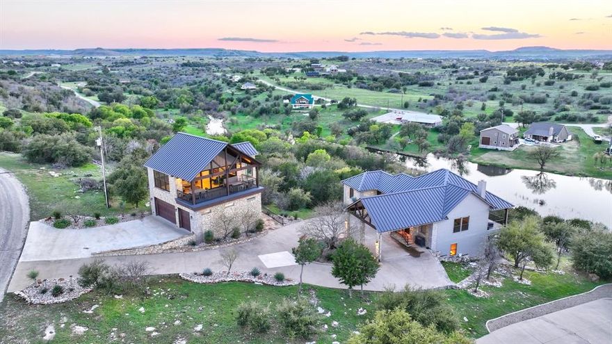 Come see this custom waterfront home that sits high on the hill of the prestigious Sportsmans World at Possum Kingdom Lake. With 4 spacious bedrooms, 3 full baths, two living areas and a two story waterfront deck in the main house, this property is perfect for family and guests to gather for memorable events yet still have privacy to relax in the evening. You will be mesmerized by the views from the floor to ceiling windows in the newly constructed 500 plus square ft. party house. This balcony offers a spectacular view of Hells Gate and the new three car garage below is an added bonus! Wait until you experience the view over the water in the one way glass shower in this unit.  The guest quarters also offers an elevator, dining and kitchen facilities for parties, visitors and events. This home offers a very unique blend of luxury, comfort and nature. It is perfect for both permanent living and getaways with relaxation, entertainment and one of a kind lake experiences. View the Matterport 3D to take a tour of this beautiful custom home.
