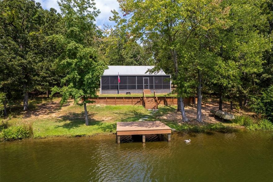 Welcome to this stunning waterfront farmhouse on Lake Princess, located in the highly sought-after Kings Country subdivision at Lake Cypress Springs. This charming home captures the perfect blend of rustic character and modern comfort, offering two oversized covered patios—one fully screened—ideal for relaxing and soaking in the beautiful lake views. Inside, the open floor plan provides a warm and inviting atmosphere with generously sized dining and living areas, perfect for entertaining family and friends. The primary bedroom is a true retreat with fantastic waterfront views, patio access, and an en-suite half bath. The kitchen is a showpiece with a farmhouse sink, butcher block countertops, stainless steel appliances, and plenty of space for cooking and gathering. Rustic design elements, including galvanized metal ceilings, shiplap walls, faux brick accents, and barn doors, add character and charm throughout the home. Across the street, two additional lots are included—one featuring a 30x25 shop with electricity and two bay doors, ideal for parking cars and storing boats. The Kings Country community offers a variety of amenities, including rentable community boat slips for easy lake access, a gated entrance, playground, sports court, and a boat ramp. This property is being sold with most furnishings, accessories and a flat bottom boat, making it a rare turnkey opportunity for lakefront living.