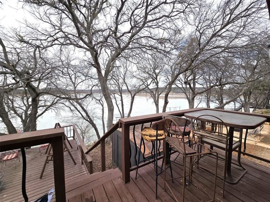 Charming two-story waterfront cottage on beautiful Lake Leon, a destination well known for excellent fishing including largemouth bass, channel catfish, and crappie—and a frequent host to bass fishing tournaments. Ideally located just 7 miles southeast of Eastland, this lakeside retreat offers the perfect blend of rustic charm and relaxed lake living. Inside, the quaint cottage showcases character throughout, highlighted by an original stone fireplace that anchors the main living space. The unique layout includes dual sleeping lofts along with an additional bedroom featuring scenic lake views, providing flexible accommodations for guests or weekend gatherings. The home also offers two full bathrooms and a bonus room with convenient walk-out access to the backyard. Outdoor living is where this property truly shines, with extensive decking and patio space designed for entertaining, relaxing, and taking in the waterfront setting. A large 24x36 shop adds exceptional functionality, offering ample room for storage, lake toys, hobbies, or a workshop. Whether you’re seeking a weekend fishing getaway, vacation retreat, or full-time lake home, this charming cottage delivers an authentic waterfront lifestyle in a highly sought-after fishing location.