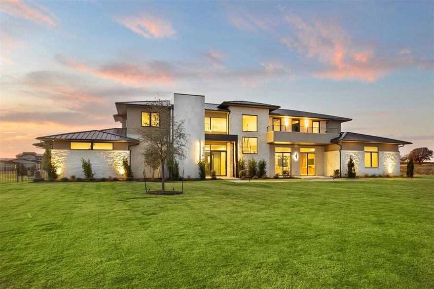 Set on two private, fully landscaped acres, this exceptional Bartonville estate blends quiet luxury, architectural craftsmanship, and modern convenience. Offering 10,420 SF under roof (6,977 SF air-conditioned) with five garage bays, the home provides rare privacy while remaining close to all that Bartonville offers, including highly rated Argyle ISD and proximity to Liberty Christian School.
A striking iron-and-glass entry, Class 4 standing seam metal roof, and expansive Andersen and Western windows create a timeless exterior and light-filled interiors. The backyard is a true retreat with a resort-style pool and spa, water features, concrete pavers, mature trees, full irrigation, and black iron fencing.
Two covered outdoor living areas are designed for year-round enjoyment—one with a gas fireplace, heaters, and TV, and the other a fully equipped outdoor kitchen with premium appliances and Phantom screens.
Inside, refined finishes include 5” white oak hardwoods, honed stone columns, Level 5 smooth drywall, 8’ solid-core doors, custom cabinetry, quartzite and quartz countertops, and layered LED lighting. The private primary suite features a coffee bar, dual custom closets, and a spa-level bath. Four additional en-suite bedrooms, a family room with gas fireplace, dining space, leisure-wine room, game and theater room, office, and gym complete the thoughtful layout. A smoked-glass residential elevator offers seamless access. 
The home is enhanced by Sub-Zero-Wolf appliances, Control4 automation, Lutron lighting, whole-home audio, advanced security, foam encapsulation, multistage HVAC, and tankless water heaters—delivering understated luxury, comfort, and effortless living in one of Bartonville’s most coveted settings.  Guest suite is large enough to be second primary and elevator to second floor.