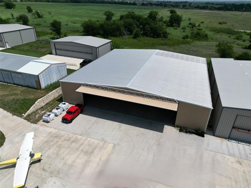 Rare opportunity to own a 10,000 sq ft airplane hangar at Bourland Field (FAA 50F), ideally positioned on a 0.51-acre lot with a large concrete pad. This well-equipped facility features a 65' x 17' Higher Power door, offering excellent access for a wide range of aircraft. Inside, you’ll find a 1,000 sq ft apartment, a 1,000 sq ft climate-controlled workshop, and 2 bathrooms, making it perfect for both aviation and extended use. The hangar is serviced by water and septic and includes a 5-ton HVAC system for year-round comfort. Bourland Field offers a 4,049' x 60' paved runway, and the location provides convenient access to the entire DFW Metroplex. Ideal for pilots, collectors, or anyone needing substantial aviation-ready space.