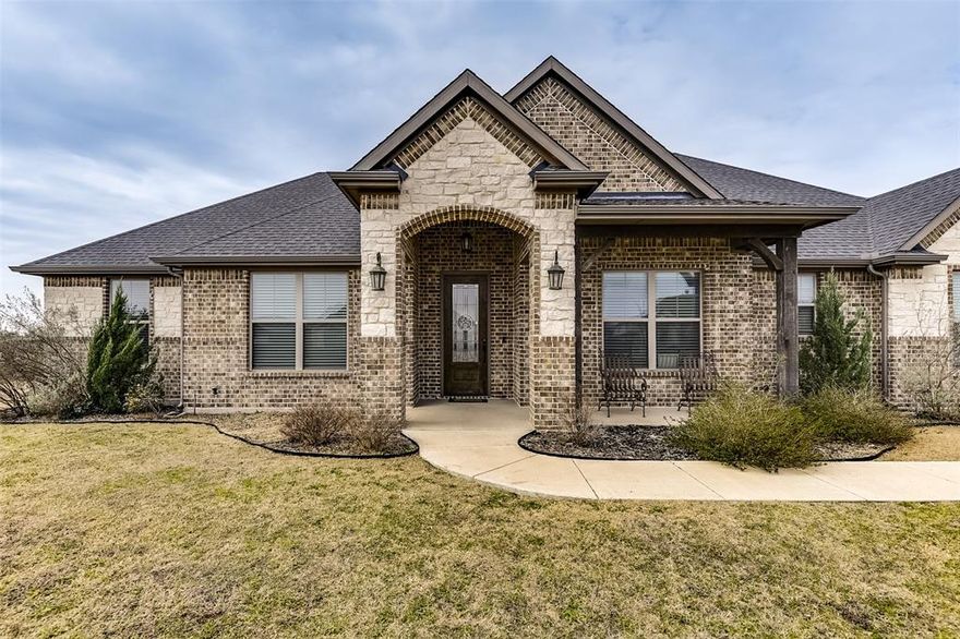 Charming 4-bedroom home situated on a full acre is a true must-see! From the moment you arrive, the side-entry 2-car garage and inviting curb appeal set the tone for what awaits inside. Step into an open-concept living space featuring beautiful wood-style flooring throughout the main living areas and a stunning floor-to-ceiling stone fireplace that serves as the heart of the home. The spacious kitchen is designed for both everyday living and entertaining, complete with an oversized island with seating, granite countertops, abundant cabinetry, and seamless flow into the living area for gatherings and hosting. The private primary suite offers comfort and functionality with dual vanities, double closets, and a separate tub and shower for a relaxing retreat. Three additional bedrooms provide generous space and with carpeting, while the dedicated study is perfect for a home office, flex space, or creative studio. Enjoy outdoor living on the covered porch and back patio overlooking the expansive yard, ideal for entertaining, gardening, or simply enjoying peaceful country-style living with room to breathe. A separate laundry room adds convenience and thoughtful detail, making this home both stylish and practical.  Schedule your showing today and make this beautiful property yours!  Buyer and Buyer’s Agent to verify square footage, taxes, and schools.