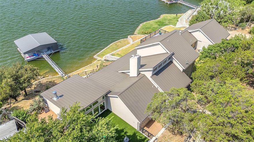 Discover a slice of paradise on the highly sought after peninsula at Possum Kingdom Lake. Situated on a double lot encompassing 1.579 acres of prime real estate. Imagine waking up to the soft glow of morning light filtering through a wall of windows overlooking the lake. This home boasts two master suites, each with its own fireplace and direct access to the expansive porch. From here, soak in endless views of the serene lake, where every sunrise and sunset paints the water in hues of pink, coral and azure. The heart of this home is its open-concept living, kitchen and dining area. The seamless flow between indoor and outdoor spaces invites you to savor the tranquility of lakeside living. Prepare to be wowed by the fully enclosed, air-conditioned outdoor oasis – a recent addition that steals the spotlight.  The  dock is your private sanctuary to dip a toe in the water, cast a line or take a short boat ride to PK's iconic spots. A property like this is far and few between.