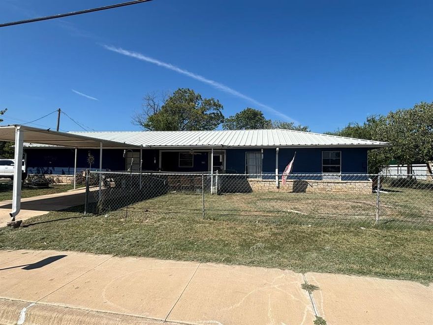 Metal roof with freshly painted siding and stone accenting give it rustic curb appeal.  This corner lot has great access with two driveways and a covered carport.  With four bedrooms and two living areas you would have all the space you need!  Extra half bath in primary bedroom for convenience.  Covered front porch, gutters, and fenced yard.  Schedule an appointment and make it yours!