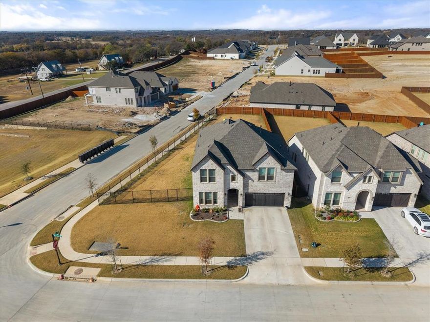 $12K SELLER CREDIT AVAILABLE WITH ACCEPTABLE OFFER! Experience luxury living in this gorgeous 2024-built home perfectly positioned on a premium .265-acre corner lot within the top-rated Aledo ISD. With $80K in upgrades, this home is designed with both elegance and functionality in mind. This 6 bedroom, 4 bath residence offers two spacious primary suites, ideal for multi-generational living or guests. Step inside to discover an open-concept layout filled with natural light and high-end finishes throughout. The chef-inspired kitchen features Calacatta quartz countertops, a gas cooktop, ceramic farmhouse sink, two generous pantries, and modern black hardware that ties the space together beautifully. The family room is a true showpiece, boasting a custom floor-to-ceiling hand-crafted TV wall mount with a digital fireplace for a cozy ambiance. There are expansive windows with motorized shades and an inviting atmosphere perfect for entertaining or relaxing. This home also has a dedicated home office designed for today’s modern lifestyle. Upstairs, you’ll find a spacious game room, a Jack-and-Jill bath with dual rainhead showers and ample sized closets. Outside, enjoy your large backyard oasis complete with a covered patio, custom-treated wood swingset, flood lighting, and a security camera system for added peace of mind. Additional highlights include a beautiful upgraded brick exterior, extra-deep garage with heavy-duty overhead metal storage racks, and thoughtful details and top-quality finishes throughout. This home truly has it ALL — space, style, and comfort in one of Aledo’s most desirable neighborhoods. Don’t miss your chance to make it yours — schedule your private showing today!