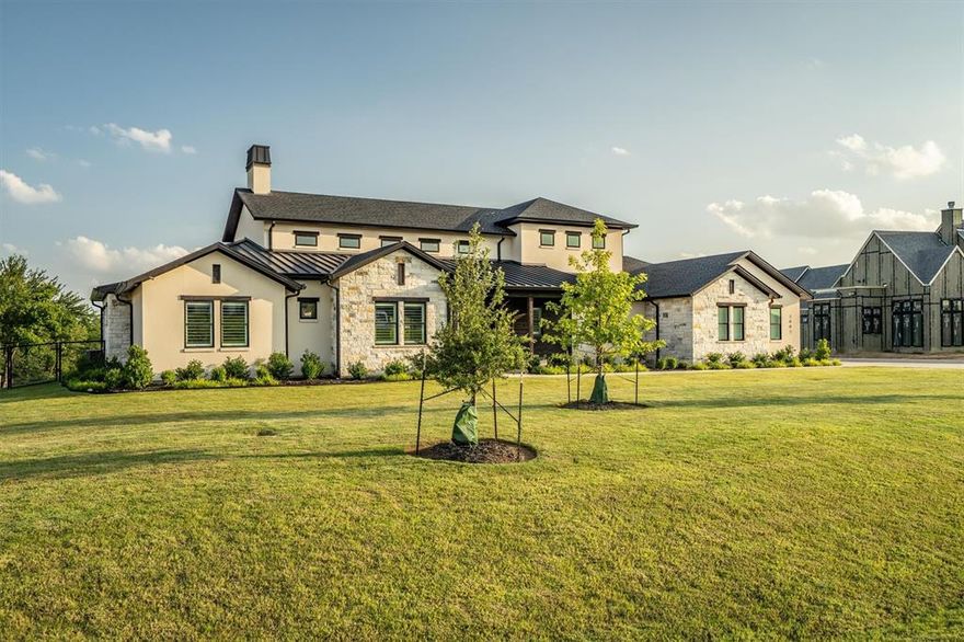 Exquisite Custom Estate on One Acre with Captivating Views! Experience luxury living in this remarkable custom-built estate, perfectly situated on a beautifully landscaped one-acre lot in the prestigious Creekview Ranch community. With sweeping views in every direction, this home offers both elegance and comfort in one of North Texas’s most desirable settings. Just outside the Argyle city limits, you’ll enjoy the advantage of lower property taxes while being part of the highly acclaimed Argyle ISD. Every detail of this residence has been thoughtfully designed, blending timeless craftsmanship with modern functionality. Step through grand double iron-and-glass doors into a stunning interior showcasing vaulted ceilings with exposed wood beams, rich hardwood floors, and a striking stone fireplace at the heart of the living space. The chef’s kitchen is an entertainer’s dream, complete with an oversized granite island, farmhouse sink, gas range, double ovens, premium appliances, and a spacious butler’s pantry with extensive cabinetry. The dining area frames picturesque backyard views, making every meal feel special. All four bedrooms are conveniently located on the main floor, each with its own private ensuite bath. The primary suite features a spa-inspired bathroom and a spacious walk-in closet for true retreat living. A dedicated office, mudroom area with built-in seating, and an elegant laundry room with abundant storage ensure daily living is both seamless and stylish. Upstairs, enjoy a media room for movie nights, a loft with custom built-ins, and a convenient half bath. Additional highlights include a 3-car garage, custom built-ins throughout, and a large covered patio perfect for outdoor entertaining. With unmatched attention to detail and an effortless indoor-outdoor flow, this one-of-a-kind estate is a rare opportunity you don’t want to miss.