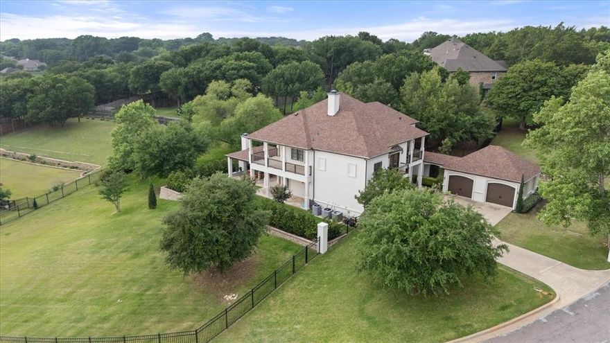 What if I told you that you could have nearly 5,000 square feet, almost an acre, and one of the best views in DFW right in the heart of the Metroplex?

Sitting at the top of a hill, this home gives you something hard to find—space, privacy, and true luxury all in one. With mature trees, incredible views, and quick access to Downtown Fort Worth, Dallas, DFW Airport, Las Colinas, and Arlington’s Entertainment District, this property stands out the moment you arrive.

The Mediterranean design makes a strong first impression with wraparound balconies, beautiful landscaping, and curb appeal that feels like a private retreat. Inside, travertine floors flow throughout the home and outdoor patios, creating seamless indoor-outdoor living. Cedar beams, solid core doors, crown molding, and a stunning cedar ceiling in the formal dining room showcase the craftsmanship throughout.

The gourmet kitchen offers abundant storage, a built in LG refrigerator, a large pantry, and opens into the oversized breakfast area and spacious family room. The formal dining room is perfect for hosting, while upstairs, the game room with a wet bar and ceiling-mounted speakers is built for entertaining.

Features two true primary suites, one downstairs and one upstairs, perfect for guests, multigenerational living, or added flexibility. Both feature oversized closets and spacious spa-like bathrooms.

Outside, enjoy your private retreat with a covered patio, gas log fireplace, built-in gas grill, beautiful fountain, and custom iron fencing around the backyard. Morning coffee overlooking the treetops brings a level of peace that is hard to find this close to the city.

Recent upgrades include a new roof, fresh interior and exterior paint, updated HVAC systems, expanded laundry and pantry space, new carpet, recessed lighting, sprinkler additions, exterior lighting, and a full alarm and camera system.

It's more than a home, it’s the lifestyle most people want but rarely find.