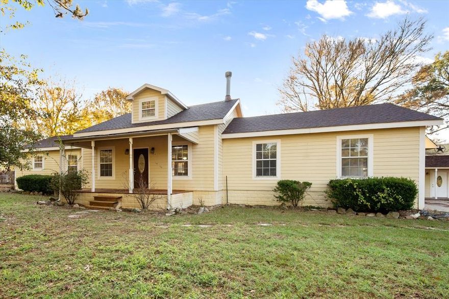 Discover the untapped potential of this unique 1.95-acre property—an investor’s dream and a creator’s canvas.  Nestled among towering mature shade trees, this charming 1-bedroom, 2-bath home with a loft offers comfort, privacy, and room to grow. Step onto the covered porches or out onto the spacious back deck, where French doors from the primary bedroom open to peaceful wooded views. Inside, the inviting living room features a cozy wood-burning fireplace — perfect for cool evenings.  What truly sets this property apart is the wealth of expandable opportunity. An unfinished out-building stands ready to be transformed to suit your vision: think mother-in-law suite, rental or Airbnb unit for lake-goers, home office, workshop, studio, craft room, man cave, she shed—or simply additional storage. With the right touch, this structure could become a major income generator or personal retreat.  The land itself is a rare find: partially fenced with a wide-open yard for recreation, yet framed by serene woods in the back. Additional highlights include an RV hookup, a spacious open-air workshop with room for equipment storage, an unfinished greenhouse frame ready to complete or repurpose, and a patio that’s wired for a hot tub or perfect for an outdoor kitchen build-out,  Bring your vision and transform this property into a personal retreat, an income-producing investment, or both.  Endless possibilities. Exceptional space.