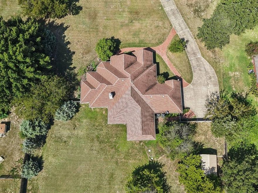 Beautiful and well-maintained custom home situated on just over an ACRE, only 25 minutes from Downtown Dallas. This inviting property offers quiet, country living in a desirable subdivision with room for kids, pets, and entertaining. The exterior features a large covered back porch prewired for a spa, a spacious fenced backyard, mature trees, professional landscaping, and an impressive exterior lighting package. Inside, the home boasts hand-scraped wood floors in the living, dining, and breakfast areas, a cozy wood-burning fireplace, and a well-designed split floor plan. The layout includes three bedrooms, two and a half baths, a dedicated study that can also function as a nursery or flex space, and an oversized all-season BONUS ROOM measuring 18x20 with views of the backyard. The kitchen offers ample counter space accented by stainless steel appliances. Additional highlights include a dual-zone HVAC system, two water heaters, oversized garage, and storage building. Located in the highly sought-after Crandall ISD, this home truly has it all! No HOA and also USDA eligible, No HOA