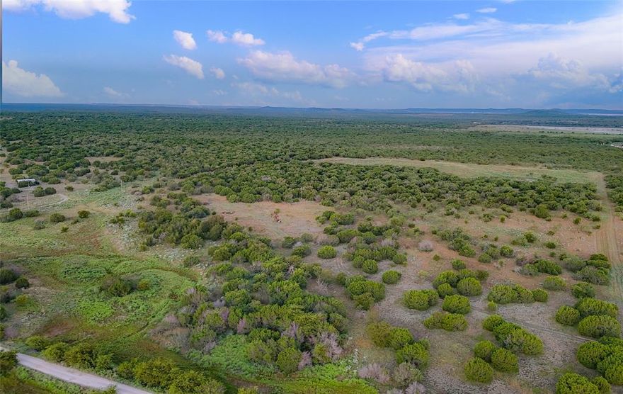 Here’s your chance to own 51.17± acres of classic North Texas ranchland located just outside Graford and only minutes from the waters of Possum Kingdom Lake. This unimproved property offers rolling terrain with a mix of native mesquite and cedar cover, as well as strong pastures of bluestem and gama grasses.

The land provides excellent wildlife habitat and plenty of privacy. For the sportsman, the ranch is ready to enjoy with one elevated blind, a corn feeder, and a protein feeder that will convey with the sale. Whitetail deer are abundant, along with other native wildlife that thrive in Palo Pinto County. While photographing the property, I personally saw several deer and a tom turkey. This versatile ranch is well-suited for hunting, recreation, or building a country retreat. Electricity is available at the road, giving you a head start on future improvements.

Downtown Graford is only minutes away, offering small-town charm with a café, feed store, and school. Possum Kingdom’s restaurants, marinas, and lake amenities are within a short drive, while Fort Worth and the DFW Airport are about 90 miles east—close enough for an easy weekend escape, yet far enough to enjoy peace, quiet, and wide-open skies. The BRA public boat ramp on Possum Kingdom Lake is just 17 miles away, providing convenient access to fishing, boating, and water recreation.

Light deed restrictions help maintain the character of the neighborhood. An assumable note is available—please contact the listing agent for details. This property is also being offered with two neighboring tracts, with additional acreage available up to 137.55± acres.

Whether you’re searching for a hunting getaway, a spot to build your dream barndominium, or a land investment in a growing area, this 51.17-acre ranch is a scenic and versatile property with an ideal location.