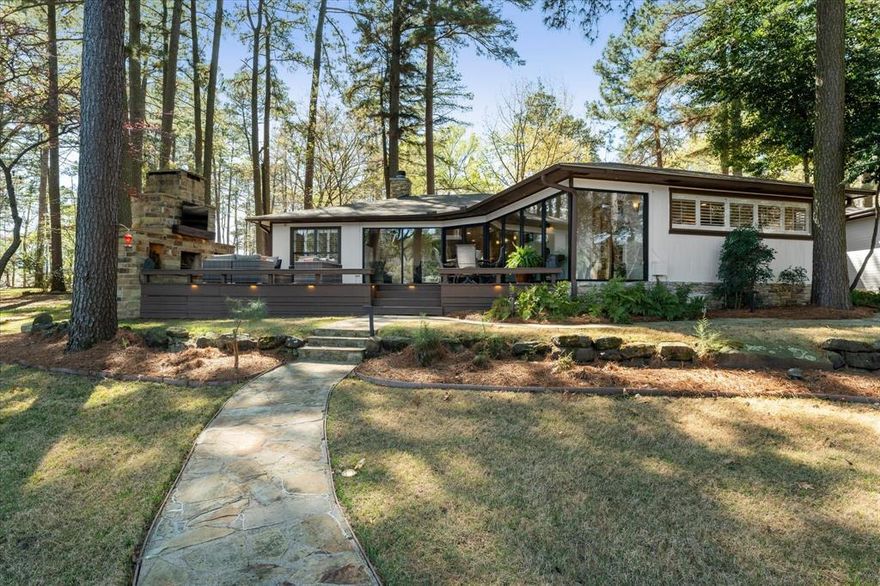 Experience luxury lake living in this BEAUTIFULLY UPDATED, fully furnished waterfront ranch home located in the gated Tall Tree community on a deep-water protected cove. Situated on a large, gently sloping lot shaded by towering pines and mature oaks, this exceptional property offers 4 bedrooms, 3 full baths, and an oversized 2-car garage. Outdoor living is simply spectacular. Enjoy sweeping lake views from the expansive deck featuring multiple seating and dining areas, a stunning stone fireplace with wood storage and TV, bug misting system, and outdoor stereo sound system. The beautifully manicured lawn is enhanced by professional landscape lighting and thoughtfully designed hardscapes, including flagstone walkways and a lakeside firepit gathering area. A two-stall boathouse with a locked storage closet completes the ideal lakefront setup. Inside, the home showcases lovely attention to detail throughout. Plantation shutters, an incredible whole-home stereo sound system, hand-scraped hardwood floors in the living areas and kitchen, and a cozy wood-burning fireplace create a warm and inviting atmosphere. Two skylights with motorized shades bring in abundant natural light. The gourmet kitchen is designed for entertaining and everyday enjoyment, featuring a built-in wine and beverage cooler, ice maker, farm sink, large walk-in pantry, and an expansive granite island with bar-height seating. All three bathrooms are beautifully appointed with oversized showers and granite-topped vanities. The home offers four generously sized bedrooms, including a spacious bunkroom with additional lounge space and an ensuite bath, perfect for hosting family and guests at the lake.  Don't miss this chance to live your dream on Lake Cypress Springs!