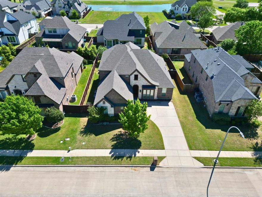 Welcome to this stunning, move-in ready home in Burleson’s desirable Thomas Crossing subdivision. Conveniently located near Southern Oaks Event Center, a golf and tennis club, and walking paths, this home offers both comfort and convenience in a prime location.

From the moment you step inside, you’re greeted by soaring ceilings, a formal dining area, and an adjacent office with glass French doors. Beyond the foyer, the spacious living room is adorned with natural lighting and a floor-to-ceiling Austin stone gas fireplace as its centerpiece.

The kitchen is designed for both everyday living and entertaining, featuring updated stainless steel appliances, granite countertops, abundant cabinet space, and a breakfast bar overlooking the breakfast area.

Privately situated off the living room, the primary suite offers comfort and retreat with an ensuite bath that includes separate vanities, a large soaking tub, and an oversized walk-in closet.

On the lower level, just off the staircase, you’ll find an additional bedroom with great closet space and a nearby full bath, making it ideal as a guest room, flex space, or craft room.

Upstairs, a catwalk-style hallway overlooks the main living area and leads to a second living area or media room. Two spacious secondary bedrooms, each with ample closet space, share an adjacent full bathroom.
Plantation shutters throughout the entire home add timeless style, privacy, and an elevated finish.

The laundry room, tucked away just off the kitchen, is a true hidden gem with built-in cabinetry and the added convenience of a sink.

Step outside to unwind on the covered patio or enjoy evenings under the stars around the built-in stone fire pit.