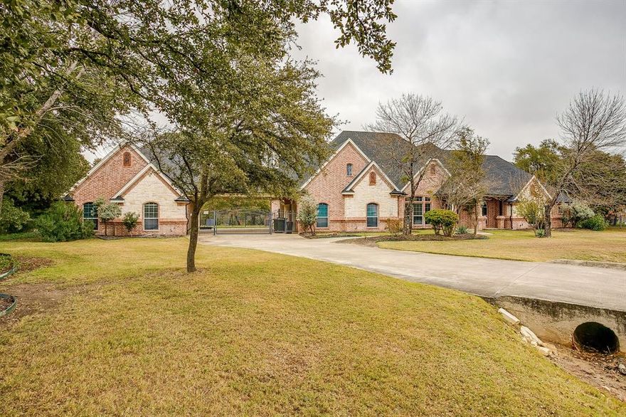 Nestled in a serene cul-de-sac in a gated community, this .99-acre property is 5 miles from Lockheed Martin. It offers both a home office and separate guest quarters. The guest house has 974 sq ft two bedrooms, a kitchen, a bathroom, living dining area, and patio. The main residence boasts Brazilian cherrywood floors, an Austin stone fireplace, an open-concept kitchen and dining space, 3 bedrooms, a den, a separate dining area, granite countertops, and an island. The upper level of the main house presents a secluded studio-style area with an office, combined living and dining space, a bedroom, bathroom, and provisions for installing a kitchen. Ample parking and storage are provided by a three-car oversized garage and a porte-cochère. The backyard is an oasis, with a color-changing diving pool, tanning ledge, oversized porch, and space for a putting green or bocce ball court, offering a perfect escape from the summer heat, all set against a backdrop of tall trees and resort-like allure.