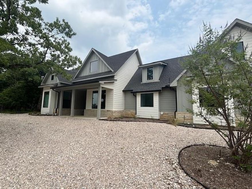 SELLER WILLING TO CONTRIBUTE UP TO $15K IN BUYER'S RATE BUY DOWN OR CLOSING COST ASSISTANCE WITH ACCEPTABLE OFFER! Step into a newly built, magazine-worthy Custom Retreat where thoughtful engineering meets elevated style with Richland-Chambers Lake across the street. Welcome to a modern country smart home that pairs head-turning style with rock-solid engineering. A gorgeous pivot steel door swings open to welcome you onto white-oak wood floors and sight-line picture windows, while spray-foam insulation, 45 twelve-inch concrete piers, and underground drainage quietly protect the structure.  All is backed by a ten-year builder warranty and two-year septic guarantee. The chef’s kitchen centers on a marble island wrapped in color-changing LEDs, a 36-inch dual-fuel range with six burners, convection microwave, Café tub dishwasher, quartz perimeter tops, and a hidden pantry finished in quartz counters inside. Those LEDs echo around the living-room TV above an electric fireplace set into a porcelain accent wall.  A two-stage high-efficiency HVAC keeps the climate weather perfect. Upstairs, a blackout-ready great room hosts a 55-inch screen and a built-in quartz bench; every room is wired with coax, and cat-6 with Ethernet upstairs in office game room.  The outdoor living with kitchen and a 55-inch patio TV, sound-bar, subwoofer, dimmable can lights, and a fire-pit invite star-lit gatherings. A manifold system offers instant whole-house water shut-off, a tankless heater provides endless hot water, and Wi-Fi cameras watch the perimeter. Fridge, and wine cooler are ready for your use. Just move on in and enjoy your dream home and write your next chapter.