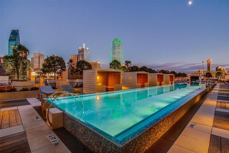 Located in the heart of Victory Park, this one of a kind double unit condo was completely reimagined in 2021, offering a rare three bedroom residence with sweeping 270 degree views of Uptown and Downtown Dallas. Designed for effortless entertaining, the open concept layout centers around a striking 13-foot kitchen island and a chef’s kitchen equipped with top of the line appliances, including a Miele induction cooktop, double Wolf ovens, two Sub Zero refrigerators, built in Miele coffee maker, and two Asko dishwashers. A walk in pantry and stylish bar area with wine fridge and additional refrigeration complete the space. Expansive bedrooms feature large closets and spa like en suites, while a private office with iron doors and built in shelving provides a sophisticated work from home setting. A versatile second living area offers flexibility for a media room, gym, or additional office.
Smart home features include Savant controlled lighting, shades, and surround sound. Additional highlights include two balconies with turf, motorized blackout shades, three reserved parking spaces with EV charging, new electrical (2021), and new HVAC systems (2024). Residents enjoy resort style amenities including a saltwater infinity pool, spa, cabanas, grills, fire pit, dog run, owners lounge, guest suite, fitness center, 24 hour concierge, valet, and security, delivering elevated living in one of Dallas’ most vibrant neighborhoods.