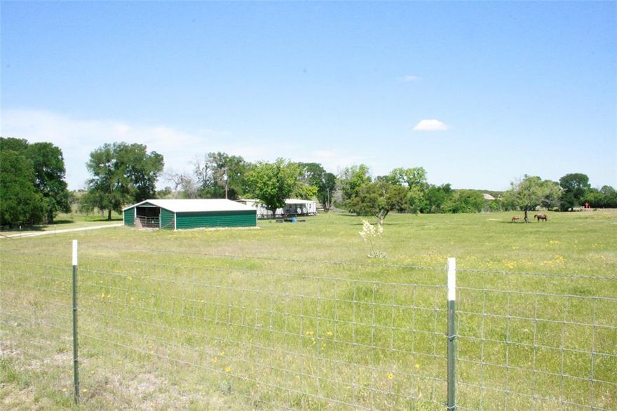 Seller just had the land cleared so you can bring your horses, cattle, goats and other livestock to this gorgeous land in Bosque County! Barndominium is situated on 9.92 UNRESTRICTED with AG EXEMPT Acres surrounded by mature oak and pecan trees. Watch the beautiful Sunrise from your front porch and the stunning Sunset from your back porch! The home features a metal roof, NEW aerobic septic with a transferable warranty, 3 large bedrooms, 2 full bathrooms, great natural light, massive front porch, back porch off bedroom, open-concept living and kitchen with a mud-utility room at the back door that opens to the attached covered carport. Plenty of room to add on and make it yours! The large carport accommodates 4 vehicles. The property comes equipped with a 40x40 barn that can be a blank canvas to make it the way you want or leave it as is with the 5 stables (2) 20x10, (2) 15x10, (1) 10x10 for feed or tack, dog kennels, round pen with a small barn, poultry coop, workshop and 50 ft tower for internet. Seller just added new road base to entire driveway. The entire perimeter is fully fenced and acreage is cross fenced for livestock. Both refrigerators convey and farm equipment is negotiable! Convenient access to I-35, Glen Rose, Lake Whitney, Stephenville, and about an hour outside of Waco.