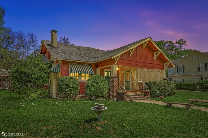 Step into timeless charm with this captivating 1918 Sears Craftsman Style Bungalow, nestled on a spacious corner lot in Minden’s Residential Historic District. From the moment you arrive, the welcoming covered front porch—with its classic square columns and brick accents—sets the tone for the character and craftsmanship found throughout this beautiful home. Inside, you'll discover original hardwood floors, a cozy wood-burning fireplace, custom built-ins, and 10-foot beamed ceilings that elevate the spacious living room. The formal dining room offers warmth and charm with a picturesque bay window, wood wainscoting, and more of those stunning beamed ceilings, making it the perfect space for gatherings and special meals. Offering 3 generously sized bedrooms and 2 full bathrooms, the home includes ample closet space and thoughtful storage throughout. The inviting kitchen is filled with natural light, creating a bright and cheerful space for meal prep and morning coffee. Unwind after a long day on the oversized screened-in front porch—ideal for relaxing or entertaining guests. A large laundry room with custom cabinetry adds even more function and convenience. Just off the carport, a 30x18 wired and plumbed unfinished shop or bonus room offers endless potential—perfect for a studio, guest suite, or home office. Academy park complete with tennis courts is only a block away.  You'll also enjoy being within walking distance to downtown Minden where you will find coffee shops, restaurants, boutiques & even an ice cream parlor! This custom-built Craftsman is a rare find with rich historic detail and modern comforts. Don’t miss your chance to own a piece of Minden’s history!