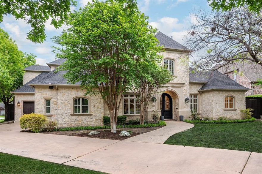 Recently transformed by an approximately $1M total remodel, this Preston Hollow residence showcases exceptional designer finishes and thoughtful upgrades throughout. Interiors were extensively renovated circa 2025 by renowned builder Ellen Grasso, complemented by a complete pool overhaul featuring new surfacing, updated tile, a spa addition, tranquil water features, and a resistance swim jet - creating a true private resort experience.

Set on a large, quiet corner lot and framed by mature specimen trees, the property backs directly to the Northaven Trail, offering immediate access for walking and cycling all the way to White Rock Lake - an exceptional blend of privacy and connectivity.

Designed for both grand entertaining and effortless daily living, the light-filled open floor plan features soaring ceilings, expansive windows, and seamless indoor-outdoor flow. The open kitchen and living area overlook a covered terrace, a beautifully landscaped backyard, and the remodeled pool, spa, and putting green. The gourmet kitchen is a chef’s dream with a 9-burner Wolf range, dual dishwashers, an oversized island, and an extraordinary walk-in pantry.

The main-level primary suite offers a spacious sitting area and spa-inspired bath with steam shower, soaking tub, dual vanities, and a custom walk-in closet with washer-dryer connections. A downstairs guest suite provides comfort for visitors, while four additional ensuite bedrooms upstairs – all with designer finished bathrooms - offer flexibility for office, fitness, or media space, along with a large game room.

A circular drive leads to both a two-car and separate one-car garage. A timeless stone façade ensures enduring curb appeal, pairing classic architecture with today’s most desirable modern updates.  Ideally located in the heart of Preston Hollow, this updated home at a compelling price is just minutes from top private schools, along with premier shopping and dining destinations.