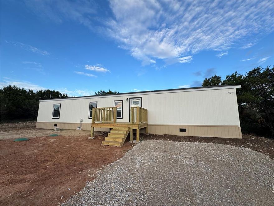 Brand new 3-bedroom, 2-bathroom Cavco home located on a double lot in Comanche Cove, Granbury. Home is set on an engineered concrete foundation designed for long-term durability. Features an open-concept floor plan with modern finishes throughout. Property is eligible for FHA and VA financing. Conveniently situated just minutes from Lake Granbury with access to community amenities.