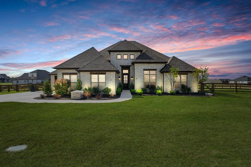 Built in 2023, this custom-built Our Country Homes single-story residence offers 4 bedrooms, 3.5 bathrooms, and 3,879 square feet on 1.84 acres with a 3-car side-entry garage. This home features an open-concept layout with dedicated spaces including a private study, game room, media room, and second living area, designed for both everyday living and entertaining. The main living area includes a fireplace with gas logs and starter, high ceilings, decorative lighting, and expansive windows providing natural light and views of the surrounding acreage. The kitchen is designed with a large island, gas cooktop, electric oven, microwave, dishwasher, disposal, pantry storage, and open flow into the dining and living areas. Interior features include walk-in closets, double vanities, high-speed internet availability, and multiple functional living spaces. Recent upgrades include perimeter fencing, interior lighting upgrades, exterior uplighting, custom built-ins in the family room and media room, approximately 8,000 square feet of added grass with additional sprinkler heads, an added play area, a whole-home water filtration system, UV lights on the air system, a switch installed for an RV and generator, and a built-in switch for the heat lamp at the well. Exterior features include a large covered patio, expansive backyard space, landscaped grounds, sprinkler system, rain gutters, and lighting. The property is serviced by propane, septic, and well systems and is situated on an interior acreage lot within Sandstrom Ranch, minutes from Eagle Mountain Lake. This Fort Worth property provides convenient access to major roadways including US-287 and I-35W, with proximity to retail, dining, and employment centers throughout the north Fort Worth area.