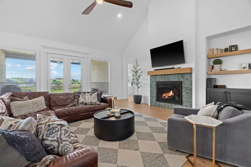 Built in 2023, this custom-built Our Country Homes single-story residence offers 4 bedrooms, 3.5 bathrooms, and 3,879 square feet on 1.84 acres with a 3-car side-entry garage. This home features an open-concept layout with dedicated spaces including a private study, game room, media room, and second living area, designed for both everyday living and entertaining. The main living area includes a fireplace with gas logs and starter, high ceilings, decorative lighting, and expansive windows providing natural light and views of the surrounding acreage. The kitchen is designed with a large island, gas cooktop, electric oven, microwave, dishwasher, disposal, pantry storage, and open flow into the dining and living areas. Interior features include walk-in closets, double vanities, high-speed internet availability, and multiple functional living spaces. Recent upgrades include perimeter fencing, interior lighting upgrades, exterior uplighting, custom built-ins in the family room and media room, approximately 8,000 square feet of added grass with additional sprinkler heads, an added play area, a whole-home water filtration system, UV lights on the air system, a switch installed for an RV and generator, and a built-in switch for the heat lamp at the well. Exterior features include a large covered patio, expansive backyard space, landscaped grounds, sprinkler system, rain gutters, and lighting. The property is serviced by propane, septic, and well systems and is situated on an interior acreage lot within Sandstrom Ranch, minutes from Eagle Mountain Lake. This Fort Worth property provides convenient access to major roadways including US-287 and I-35W, with proximity to retail, dining, and employment centers throughout the north Fort Worth area.