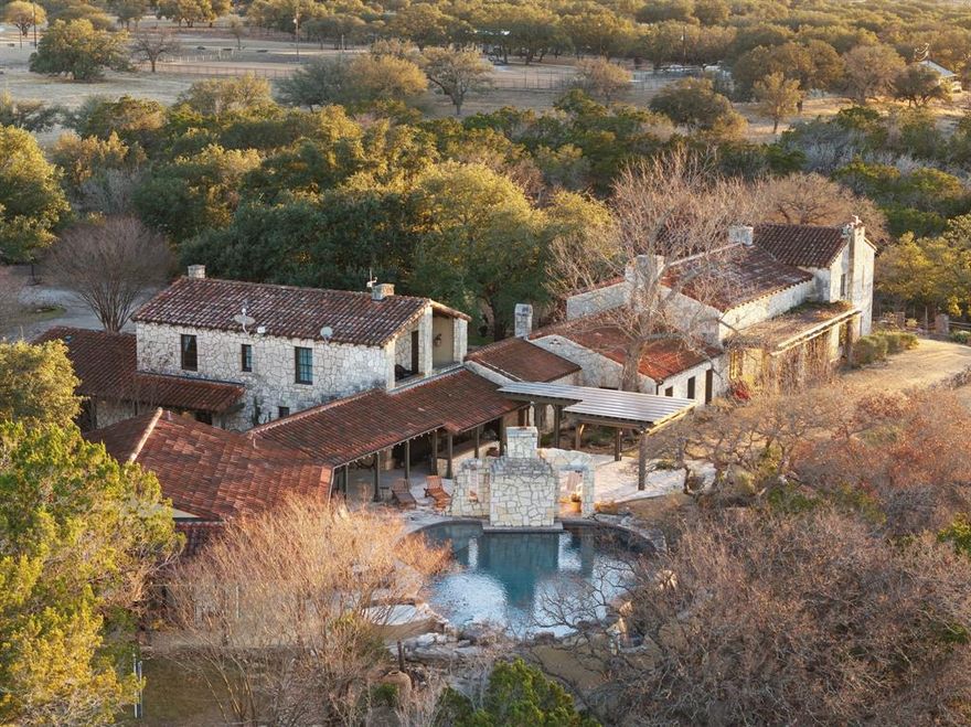 Welcome to Rio Ranchito, a crown jewel of the Texas Hill Country, nestled along the dramatic limestone cliffs of the Guadalupe River in storied Hunt, Texas. This 168 acre legacy property embodies refined Western living at its highest level—where luxury, nature, and lifestyle come together in perfect harmony across a pristine landscape designed for both grand entertaining and peaceful seclusion. At the heart of the ranch sits the fully updated 6-bedroom, 6-bath main residence, a lodge-inspired architectural masterpiece with commanding views of the river and surrounding bluffs. The soaring great room with exposed timber beams and massive fireplace invites the outdoors in, while expansive terraces and lush courtyards provide serene gathering spaces for every season. The primary suite is a private sanctuary, complete with a spacious balcony, spa-inspired bath, and breathtaking views. Outside, an infinity-edge pool and spa cascade visually into the river valley below, flanked by a fully appointed pool house, ideal for summer afternoons and sunset cocktails. Entertain in style with a spacious game room, private office, gourmet kitchen, and multiple indoor outdoor living areas that effortlessly. Steps away, the newly rebuilt River House features 4 bedrooms, 3 baths, and a clean, contemporary interior with never-lived-in finishes and unobstructed riverfront views. For equestrians, a premier 26-stall barn includes an outdoor arena, eurosizer, round pen, and a barn office with full bath—crafted for serious training and everyday care. The ranch also features an impeccably designed Dog House with 12 individual kennels, custom dog houses, and runs. Infrastructure includes covered a quail barn, hay storage, trailer parking, a charming bunkhouse, manager’s residence, and two additional staff homes. Whether entertaining guests, training horses, or simply living the Hill Country dream, Rio Ranchito offers an unmatched combination of luxury, land, and lifestyle.