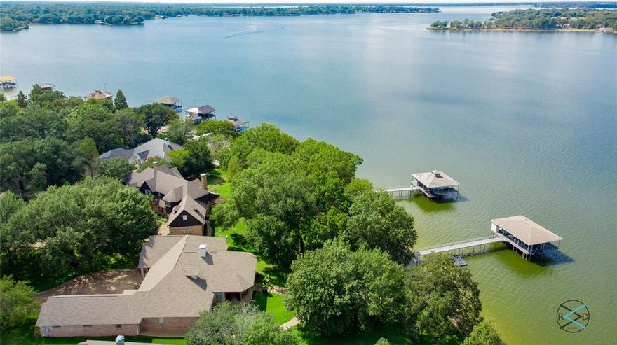 Exclusive gated community, high-end interior renovations, multiple living areas,  game room , chef's kitchen with  quartz counters, stunning setting with half - acre lot, mature trees, and an impressive 159 feet of shoreline plus stone fire pit and double boathouse in deep water.