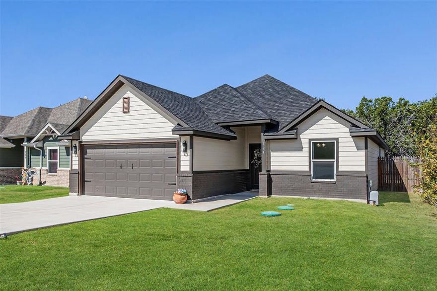 Cute, cozy, and clean 1 owner home located in the heart of Granbury in the community of Comanche Cove. Built in 2023 this home is practically brand new. 3 bedrooms, 2 full baths, featuring 1492 square feet of open concept space! In this home you will find NO carpet. Beautiful wood laminate flooring throughout for ease of cleaning! Inside you will find granite countertops in the kitchen, master bathroom, and guest bathroom. Full stainless appliances in the kitchen. Refrigerator, cooktop stove, built in microwave, dishwasher, washer, and dryer. Just off the kitchen is a very nice breakfast area that looks out to the backyard. All rooms have ceiling fans perfect for the hot Texas summers. Master bedroom is large enough for a king size bed and more! Master bath features double sinks and his and hers closets! Bedrooms 2 and 3 are roomy and both have walk in closets. This home shows pride of ownership throughout and is spotless clean! Outside you will find full sod front and back yard, wood privacy fence, 2 car garage with opener, covered front porch and back patio. Very low cost HOA includes a clubhouse, community pool, park, boat ramp, and Lake Granbury access.