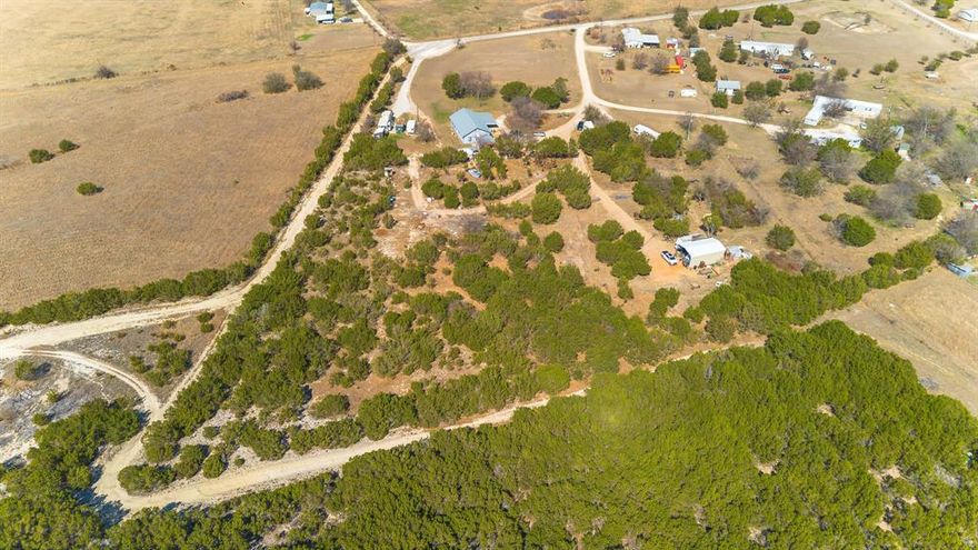 Approximately 6 acres of rural living with this exceptional property. This elevated parcel offers ample space with a unique sloping terrain that stretches from the back to the front of the parcel. Step into a world of possibilities with a 3 bedroom 2 full bath home with an open floor plan which invites endless customization to suit your vision. Whether you’re looking to create a personal haven or invest in an income-producing venture, this property provides a blank canvas for your dreams. There are 4 RV spots, 3 with water and electricity currently being leased month to month. One spot has electricity only. There is a nice outbuilding which holds a workshop, the water cistern and pump. There is an option to access county water if your preference. The landscape's natural slope not only adds character but also enhances drainage and scenic views, making it a standout feature for potential developments or recreational uses. Engage with the tranquility and beauty of Glen Rose, known for its captivating landscapes and rich history, state park, shopping and restaurants. This property offers more than just land—it offers an opportunity to craft the lifestyle you've envisioned.