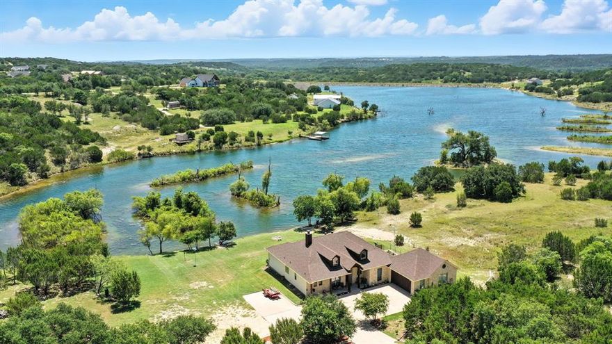 LAKE FRONT PROPERTY: Four bedroom, 3 full bath home conveniently located on Anglers Cove Lake in beautiful Bluff Dale, Texas with an incredible 2+ acres that has over 261' of WATERFRONT. Home features spacious open concept living with built-ins, breakfast bar, newer stainless steel appliances, floor to ceiling rock fireplace, stained and etched concrete flooring, wall of windows showing off the fabulous lake front and wildlife that live on and around this property. The primary bedroom is large with windows showing off the beautiful scenery and holds an ensuite consisting of jetted garden tub, walk in shower and double vanities and spacious closet.  New 16 seer AC heat pump & kitchen sink, outdoors you will find a sprawling over sized back porch perfect for relaxing drinking your favorite beverage in the morning while watching the sun come up and evenings watching wildlife gather at the water's edge.  The sprinkler system comes in handy in the summertime, fenced garden area, 12x16 stg bldg with10x14 lean to that will hold your mower & outdoor toys. Seclusion from road frontage and plenty of elbow room, this you need to see if you are wanting your very own staycation.