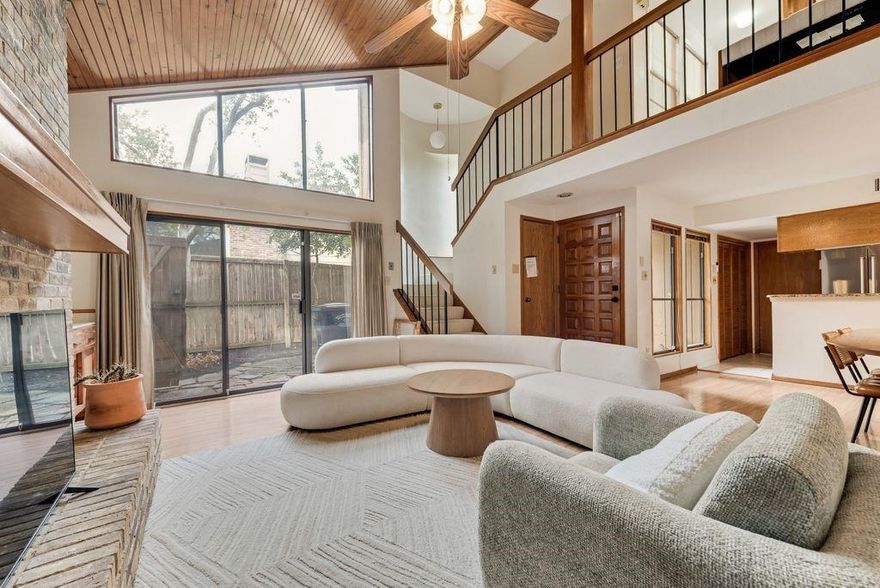Tucked away on a quiet cul-de-sac in East Dallas, this architecturally distinctive residence blends modern design with warm, natural elements to create a home that is both refined and inviting.

Vaulted wood-plank ceilings and expansive windows define the main living space, filling the home with natural light and drawing the eye upward. A striking brick fireplace anchors the room, while built-in shelving and thoughtful detailing add both character and function. Sliding glass doors create a seamless indoor-outdoor connection to the private patio.

The kitchen is both stylish and practical, featuring granite countertops, stainless steel appliances, and warm wood cabinetry, all flowing easily into the dining area—ideal for everyday living and casual entertaining.

The primary suite is located on the main level and is highlighted by vaulted ceilings, natural light, and direct outdoor access. The primary bath offers a split layout with a dual-sink vanity and freestanding soaking tub on one side, and a separate single vanity, glass-enclosed shower, and toilet on the other.

Upstairs, a versatile loft overlooks the living area below, offering a flexible space for a home office, reading nook, or secondary lounge. A private secondary bedroom and full bath offer flexibility for guests or additional living needs.

Outside, the wraparound patio and turf yard offer a low-maintenance outdoor setting with multiple areas to relax or entertain, all within a gated, private space.

With its distinctive architectural character, functional layout, and convenient location, this home offers a rare opportunity to enjoy both thoughtful design and everyday livability in one of East Dallas’ most accessible neighborhoods.