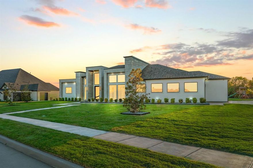 Discover unparalleled luxury in this stunning 5-bedroom, 5.5-bath residence located within the coveted Ridge Lakes community. Crafted as a single-story marvel, this architectural gem maximizes light flow and captures awe-inspiring views of every sunrise and sunset. Towering 22-foot ceilings, expansive panes of glass, and grand proportions define a space that blends elegance with functionality. The primary suite offers a serene escape, featuring a spa-like bath with private his-and-her areas and a bespoke wardrobe solution. Attention to detail shines through premium materials, including fine wood floors, hand-chosen stonework, and custom lighting accents. Enjoy a thoughtfully designed layout boasting a dedicated workspace, fitness area, game zone, serene meditation room, and state-of-the-art theater, all centered around a stunning pool that creates a seamless indoor-outdoor connection. Outdoors, entertain effortlessly with a professional grilling station alongside a handcrafted brick oven. This extraordinary property exemplifies contemporary sophistication, blending comfort, style, and timeless appeal.