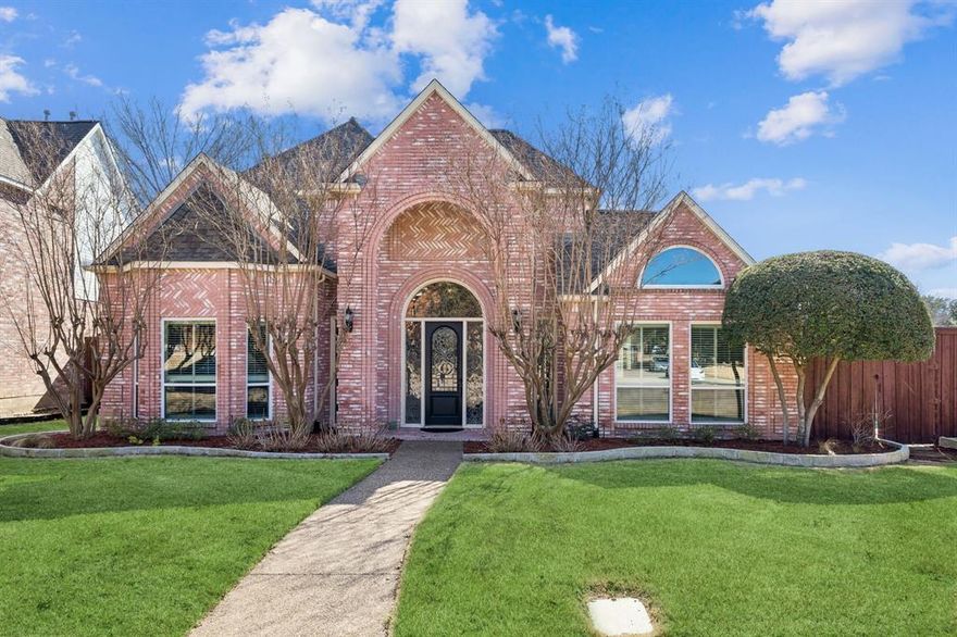 Welcome to 18016 Benchmark Dr, a beautiful and spacious home in Far North Dallas, zoned for Plano ISD. Step inside to a grand foyer with a sweeping staircase that sets the tone for this elegant yet welcoming residence. To the right, enjoy a formal living room with a wet bar- ideal for entertaining- while the formal dining room to the left offers an ideal setting for hosting family and friends. Continue into the light-filled family room, which opens seamlessly to the kitchen and breakfast nook, creating an inviting open-concept space for everyday living. The oversized primary suite is conveniently located on the first floor and features an ensuite bath with a garden tub, separate shower, dual vanities, and a generous walk-in closet. A secondary downstairs bedroom, currently used as an office, offers flexibility as a guest room, home gym, or study. Upstairs, you’ll find three sizable bedrooms providing plenty of space for family or guests. Step outside to your private backyard oasis featuring a resurfaced pool (2022), low-maintenance turf, a putting green, and an outdoor kitchen- perfect for relaxing or entertaining year-round. Conveniently located with easy access to the Dallas North Tollway and PGBT, and just minutes from top-rated restaurants, shopping, and entertainment, this home offers the perfect blend of comfort, convenience, and lifestyle!