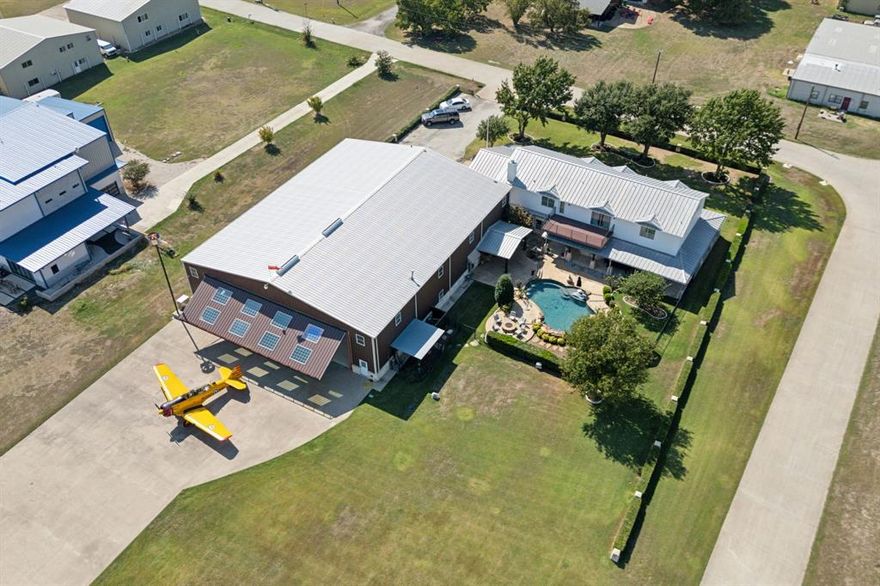Luxurious fly-in estate; discover the ultimate aviator's property! This rare residential airport property spans 1.27 acres and features a stunning 4,819 sq ft luxury ranch-style home facing the runway at Aero Country Airport (T31), midway between Frisco and McKinney. The exquisite two-story residence boasts 4 bedrooms and 4.5 baths, designed for both comfort and elegance. Adjacent to the home is a massive 8,000 sq ft hangar complete with a secondary 1,200 sq ft 2-bedroom, 1.5 bath residence, ideal for guests or pilot’s quarters. Dive into relaxation with an inviting pool featuring captivating rock waterfall features, hot tub and propane fire pit. Enjoy watching aircraft take off and land from your own backyard oasis. Enjoy the tranquility of country living with Sprouts Farmers Market and Home Depot just minutes away. Prosper Independent School District, perfect for future aviators! Access to the 4,352' x 60' runway with 100LL self-serve fuel available on the airfield.
