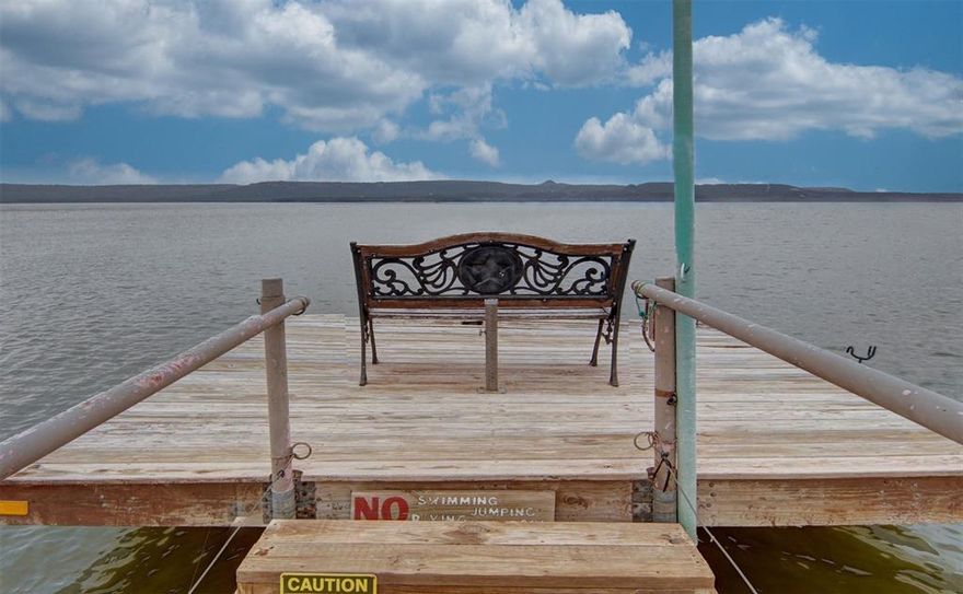 Lakefront home on the peaceful North Shores of Possum Kingdom Lake surrounded by mature trees. The main home offers large open living space. Eat in Kitchen with gas range. Dining space with dry bar and tons of storage options. The oversized primary bedroom with ensuite bath boasts a garden tub, dual sinks and 2 extra large walk in closets. Two guest rooms separated by 2nd bathroom offer ample space for guests. The separate bunk house with 2 additional bedrooms and half bath, make this property ideal for rental investment. Huge kid friendly play yard and sandy beach lake frontage. Expansive covered lakeside deck to wile away the hours, entertain or just take in the unbeatable sunsets. Jump in the lake from your swim platform dock or tie up your watercraft. Plus this property is ideally located within walking distance to PK Airport. Don't let this one get away!