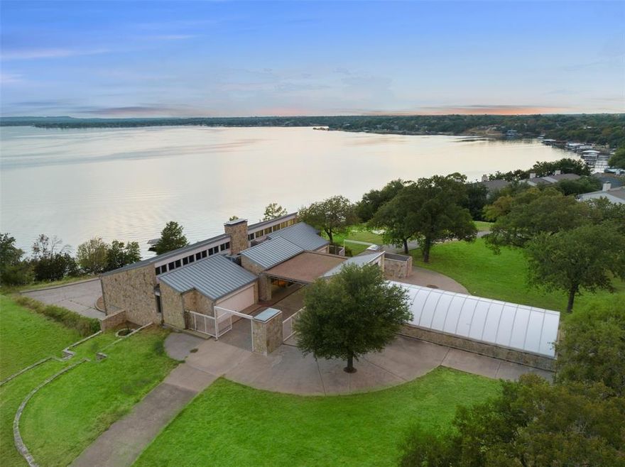 This serene, custom-built estate is privately gated and nestled on nearly 17 acres of picturesque land in Granbury. The property features a stunning park-like drive, winding through natural beauty before opening up into a spacious circular drive leading up to the estate. The estate boasts breathtaking panoramic views of the lake, with nearly 420 feet of pristine waterfront. 

The home welcomes you with a porte-cochère at the entrance. Inside, the foyer opens to a full bar and gathering area, highlighted by a floor-to-ceiling stone fireplace. The expansive living room flows seamlessly into the formal dining room, which connects to the kitchen and breakfast area—all offering spectacular lake views. The kitchen is equipped with high-end stainless steel appliances, including a wine fridge, ice maker, and Subzero refrigerator, as well as a generously sized walk-in pantry and laundry room.

The  primary suite includes a spa-like bath with separate his-and-her sides, with large closets. There is a sitting area leads out to a private balcony. There is a private study, also has balcony access, offers an ideal space for work or relaxation. The second floor features five spacious bedrooms, each with its own ensuite bath, as well as a large family room with captivating lake views. This is also an excellent investment or development opportunity.
