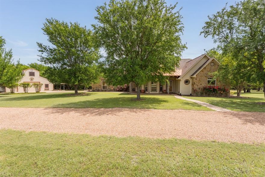 Welcome to your own private retreat nestled in the gated community of Blue Branch Ranch, where charm, character, and craftsmanship come together on over 2 gorgeous acres. Framed by a natural tree line that creates a peaceful sense of seclusion, this stunning home greets you with undeniable curb appeal — a beautiful blend of stone, siding, and copper accents that set the tone for everything inside. Step onto one of the multiple covered porches and feel the stress of the day melt away. Inside, a crisp and thoughtful layout welcomes you with clean lines and an abundance of architectural detail — from high ceilings and vaulted ceilings, rich wood floors to warm wood accents, skylights that bathe the space in natural light, and windows that frame the beauty of the surrounding landscape. The expansive living area flows seamlessly into the kitchen and breakfast room, creating the perfect space for everyday living. The kitchen features large windows above the sink — a simple luxury you'll never take for granted — plus a separate dining room that makes entertaining effortless. Retreat to the generously sized primary suite that is sure to impress: dual vanities, a jetted tub, a separate shower, and yes, you’ll have two walk-in closets. No sharing required! Two additional bedrooms offer comfortable accommodations for guests, while the large laundry room doubles as a pantry, and a convenient half bath keeps the main living areas private. And then there's the showstopper: a massive 1,700 sq ft two-story barn that takes this property to a whole new level. Complete with an office, two 220-volt outlets, additional covered parking, and a workshop or hobby space, the possibilities are endless. Whether you're dreaming of a home business, a creative studio or something else. With an attached two-car garage, a circle drive to add plenty of parking, mature trees, and room to breathe, this gem is a rare find. Lets not forget to mention the 2025 HVAC and that the roof was replaced in 2021!