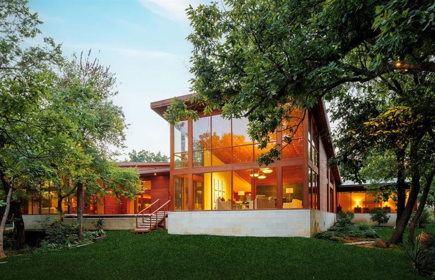 Discover one of Dallas' most extraordinary residences, a stunning retreat nestled on over 2 acres of lush, private greenery. This architectural masterpiece, designed by renowned Interior Designer Barbara Daeske in 2010, combines unparalleled craftsmanship with finishes sourced globally, including teak wood from Myanmar, recycled hardwoods from India, Brazilian limestone, Quartz stone from South America, and custom handcrafted lighting. This masterpiece offers over 7,100 square feet of luxurious living space, with the primary suite on the first floor and framed by breathtaking views of the surrounding nature. The upstairs provides two additional bedrooms, each with its own ensuite bathroom, perfect for guests or family. Energy efficiency meets opulence, as the home is equipped with a cutting-edge geothermal system for heating and cooling, ensuring comfort year-round. Its location combines tranquility with convenience, offering walkability to some of Dallas' finest dining and shopping, while being just minutes from all major highways and easily accessible to DFW, Dallas Love Field, and Addison Airports. For the discerning buyer seeking unmatched elegance and exclusivity, this property offers a one-of-a-kind living experience in the heart of Dallas.