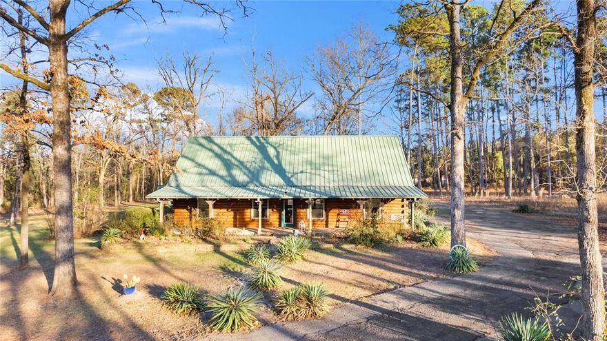 Is there any better place to be snowed or iced in than a log home, powered by a whole-house generator and warmed by a freestanding wood-burning stove at its heart? Escape to the heart of East Texas with this stunning 4-bedroom, 3-bathroom log home nestled on 3.2 beautifully landscaped acres in Quitman TX. Perfectly positioned for those seeking a peaceful sanctuary without sacrificing convenience, this property is located less than two hours from Dallas and under an hour from Tyler, making it an ideal full-time residence or a weekend retreat. Step inside to a warm and welcoming atmosphere where natural wood finishes meet timeless craftsmanship. The heartof the home is a spacious kitchen designed for both daily life and hosting guests. The living area features a classic wood-burning stove, providing a cozy focal point for cool Texas evenings, while modern electric heating and water heating systems ensure year-round comfort and efficiency. The home has a backup Generac generator The 3.1-acre grounds are a nature lover’s dream, featuring mature landscaping that offers exceptional shade and privacy. Relax on the covered front deck or the large wood deck in the backyard, an ideal spot for morning coffee or hosting summer barbecues. The home is topped with a durable, low-maintenance metal roof, offering superior protection and long-term peace of mind. For the hobbyist or craftsman, the property includes a versatile detached garage and workshop complete with a storage loft. Additional carport parking provides plenty of room for vehicles, boats, or equipment. Located just minutes from the world-famous bass fishing at Lake Fork and the historic charm of downtown Quitman, this estate offers the quintessential East Texas lifestyle. Experience the perfect blend of rustic character and modern utility.Schedule your private showing today!