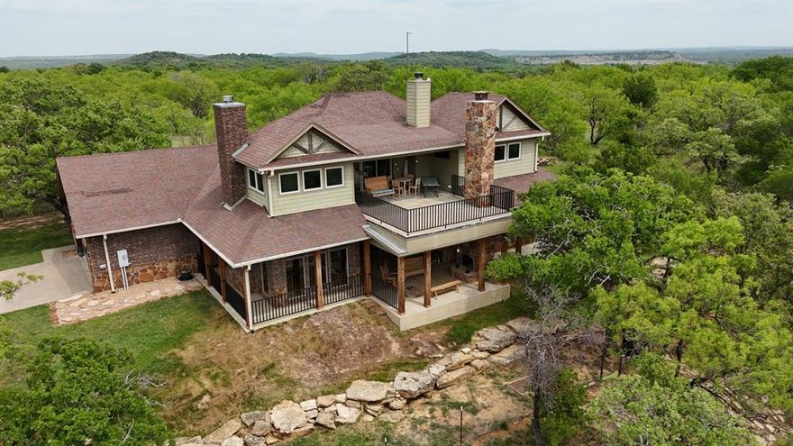 Welcome to your Texas haven, nestled on 18 rolling acres in Jack County and midway between Fort Worth and Wichita Falls. Through the gated entrance, you’ll find peace, privacy, and a beautifully crafted 4-bedroom, 3.5-bath home spanning nearly 3,800 sq ft that perfectly blends rustic charm with modern comfort.

Inside, Colorado blue pine ceilings, hardwood floors, and natural light create a warm, inviting feel. The living room centers around a powerful stone fireplace that heats the home, while a second fireplace adds charm to the dining area.

The kitchen is a showpiece; featuring an induction cooktop with pot filler, two electric convection ovens, touch faucets, copper sinks, granite counters, and stainless, energy-efficient appliances. The primary suite offers a spa-like bath with jetted tub, separate shower, and walk-in closet. Upstairs, a catwalk overlooks the living area and leads to additional bedrooms and a balcony with sweeping views.

Step outside to enjoy two 19x22 covered patios, an outdoor kitchen with propane grill, fridge, and fire pit, and peaceful sunsets over rolling hills. The home is built for efficiency with spray foam insulation, energy-efficient appliances, smart thermostat, individual bedroom controls, water softener, reverse osmosis, and rainwater collection.

Additional features include an oversized garage with sink, RV or boat parking by the pond, and a five-stall barn with partitioned corral. The home site itself is fenced separately from the remaining acreage, making it ideal for horses or livestock.

With panoramic views, scattered hardwoods, and wide-open skies, this Jacksboro property truly captures the essence of Texas living.