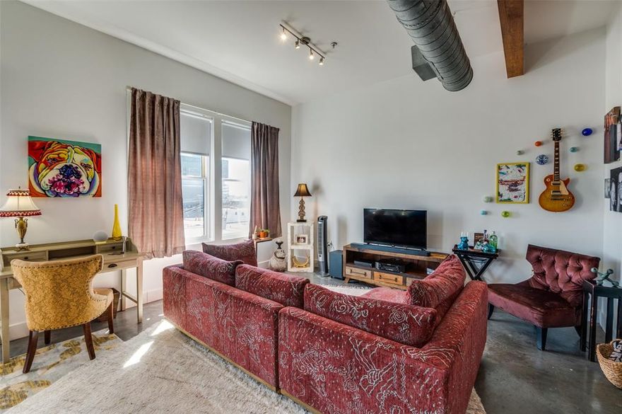 Rare opportunity to own an extensively updated loft style condo, offering East Dallas views through tall windows in a bright and open floorplan with 10' wood-beamed ceiling. The newly remodeled kitchen is the focal point of the open layout that integrates living, dining & kitchen areas. The sparkling kitchen showcases a full Bosch appliance package, gleaming quartz counters, polished concrete floor, and a custom tile backsplash. The home is brightly lit with morning sun but can be darkened with remote controlled solar powered blinds along the wall of oversized windows. The generous open plan living area has polished concrete floors and enjoys expansive views as you look down on the city below. The bath has been updated with a spa-like frameless glass shower enclosure and chrome rain spray head, ceramic floors, granite counters and upgraded cabinetry. Other amenities include a walk-in closet, exposed ducts, exposed wood beams & columns, secure entry garage with assigned parking, a fitness center, landscaped private courtyard swimming pool, and a great downtown location convenient to everything. Retro refrigerator, Washer & Dryer are negotiable.  Most furniture & decor available for separate purchase.