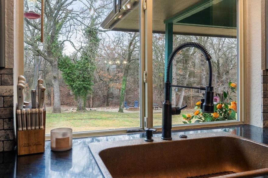 Nestled on 1.5 acres of picturesque land, this stunning 3-bedroom, 2-bath home offers a perfect blend of comfort and charm. A hidden office and a bonus gym room—both not included in the tax square footage—provide extra space for work and wellness. The primary suite is a true retreat, featuring a cozy fireplace by the bed and a luxurious en-suite bath with gorgeous copper sinks, a copper soaking tub, and a fireplace for ultimate relaxation. A walk-in shower adds to the spa-like experience.

Step outside to enjoy breathtaking landscaping, a serene koi pond, a treehouse, and an inviting outdoor seating area with a fire pit—perfect for entertaining or unwinding in nature. With well water and mature trees surrounding the property, this home offers a private and peaceful escape while maintaining easy access to modern conveniences. Don't miss out on this unique and beautifully designed property!