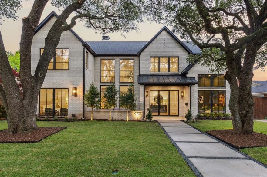 Stunning new construction by Gramercy Custom Homes on an oversized 70-ft wide lot in Lakewood, framed by mature live oak trees. This thoughtfully designed home features a custom floating staircase, museum-finish walls, and oversized windows for incredible natural light. The chef’s kitchen includes luxury commercial-grade appliances, hidden prep pantry, and a stylish bar. Incredible 16-ft sliding door off the spacious living area opens to a covered outdoor retreat—complete with fireplace, Bromic heaters, built-in speakers, and a well-equipped grilling station. The beautifully shaded, turfed backyard is perfect for year round enjoyment and includes a 3-hole putting green. The home’s versatile layout offers a private downstairs guest suite, office with custom built-ins, mudroom, and flex space perfect for a gym. Upstairs, enjoy a vaulted owner’s suite with spa-like bath featuring luxurious soapstone countertops and a fully custom closet. Also upstairs is a second living area with wet bar, 3 ensuite bedrooms, and a swoon-worthy laundry room. Other highlights include an oversized 700 sq ft garage with epoxy floors, full smart home including security cameras, and 8ft board-on-board privacy fence with automatic gate – all within walking distance of the SoPac Trail, White Rock Lake, and Lakewood Park, and an easy drive to Downtown Dallas.