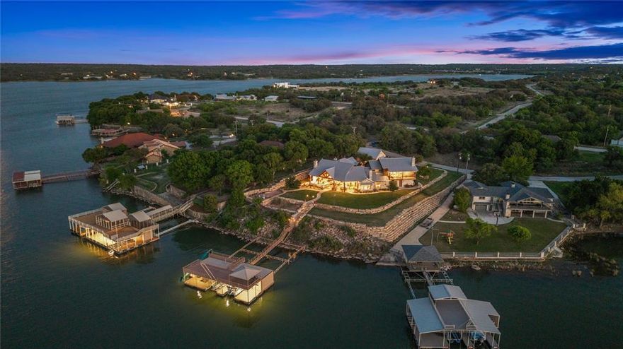 We are proud to introduce one of the most stunning lake houses on Lake Brownwood in the hill country of central Texas. This timeless ranch-style home is situated on a point overlooking the stunning sunsets that only Texas offers. The great room has a two-story rock fireplace and vaulted ceilings, which are replicated in the outdoor living room, presenting a stunning view of the lake. For the chef in the family, the grand kitchen features rock accents, a large island, a NXR 6 burner gas range, double ovens, and a Sub-Zero double built-in refrigerator. There will be plenty of room to gather with the family room open to the kitchen, which has another cozy fireplace. The lake view from the main areas of the house is unmatched. The spacious floor plan is well-thought out, with 5 bedrooms and 4 bathrooms. Be ready to be blown away by the view of the master suite which is situated up the second stairway and includes a seating area with rock fireplace, private balcony overlooking the lake, coffee bar, and incredible master bath. There is space for an elevator should the new owner choose. There is no better place to enjoy the sunset than in the outdoor living area which includes soaring ceilings with cedar beams, large cooking area, fireplace, grill, sink, large bar, lounging and dining areas all overlooking beautiful Lake Brownwood. There is plenty of room for cars, boats, storage etc. with 5 garage spaces. Get ready for plenty of lake fun on the dock that has it all, with two boat slips with hydro-hoists, two personal watercraft lifts, crappy hole, slide, trapeze swing, and upper deck. The property is located in the Hideout Golf Resort, providing family fun that includes a resort-style swimming pool, golf course, tennis courts, pickleball courts, restaurant, RV park, fishing dock, and rental properties for overflow.
